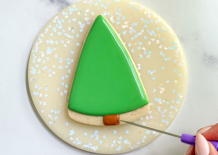 Image of Fill in the small square shape with the same brown outline consistency icing and use your scribe tool or toothpick to smooth out the icing. 