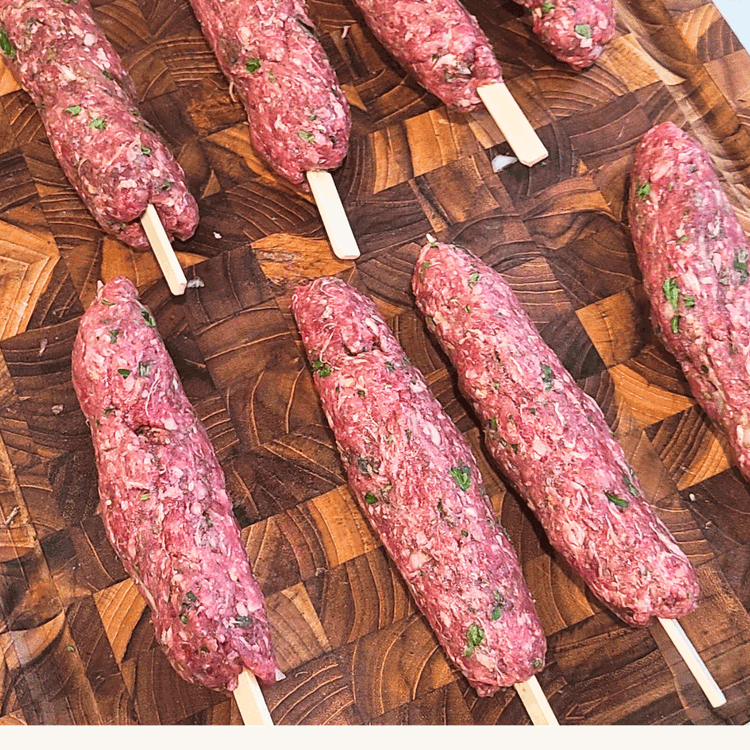 Image of Divide the mixture into eight equal parts. Form the meat into an oblong shape on the skewers.