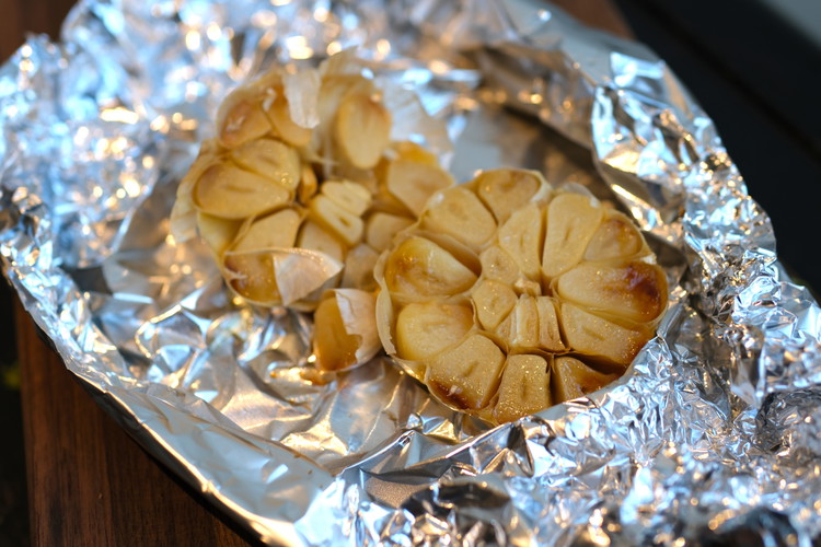 Image of roast at 375 for 40 minutes until garlic is fragrant and cloves are soft. let cool and squeeze cloves out of the paper.