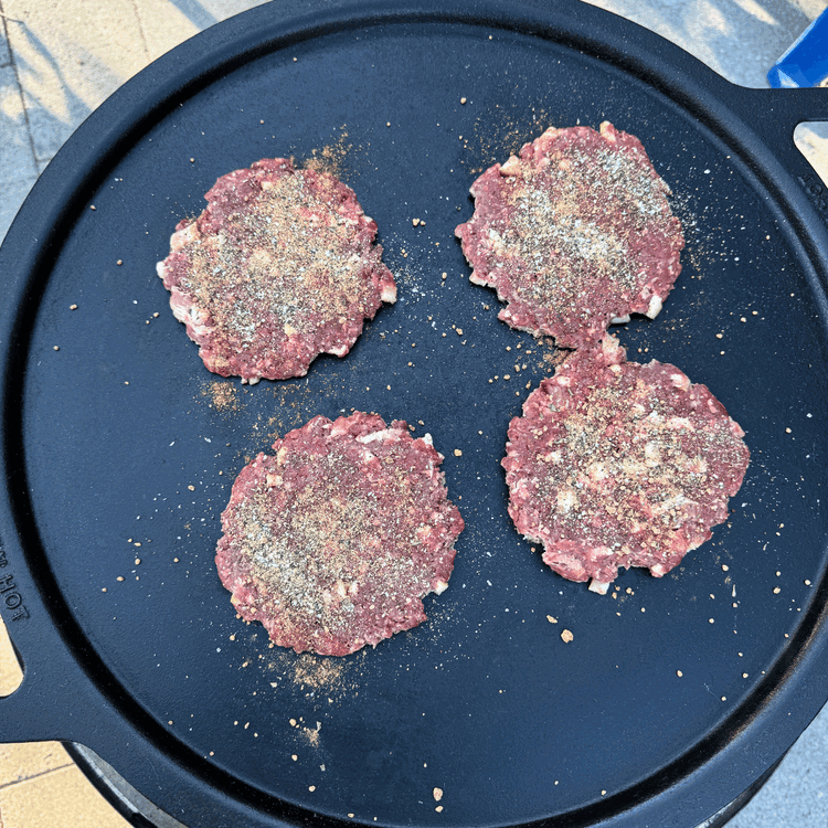 Image of Once the cast iron is hot, set the balls on the griddle, then use a burger smasher to smash the patties. Season the top side of the patties.