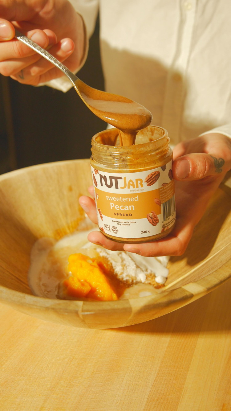 Image of In a large bowl, whisk together the pumpkin puree, sugar, yogurt, pecan spread, melted butter, vanilla extract, and apple cider vinegar. Mix until combined.