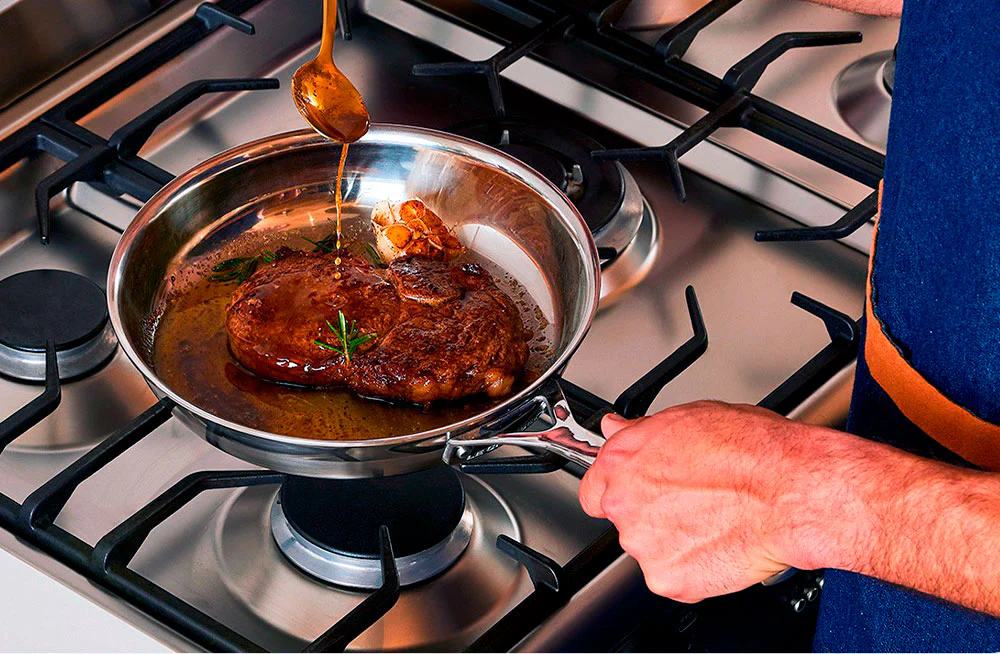 Steak avec sauce au beurre au thym dans une poêle inox