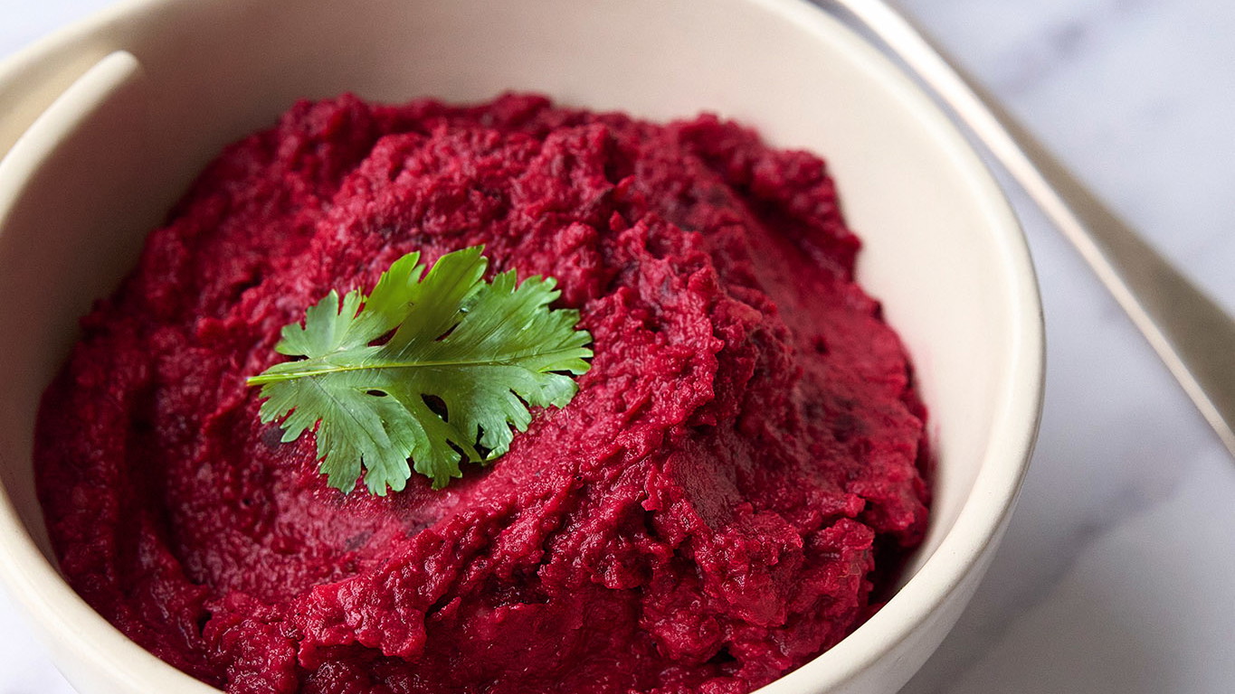 Bowl of houmous made with beetroot and haskapa