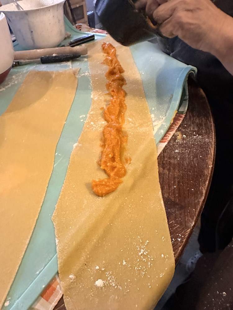 Image of Put your filling in a piping bag or a ziplock and cut the corner. Squeeze a long line of filling in the middle of your dough strip.