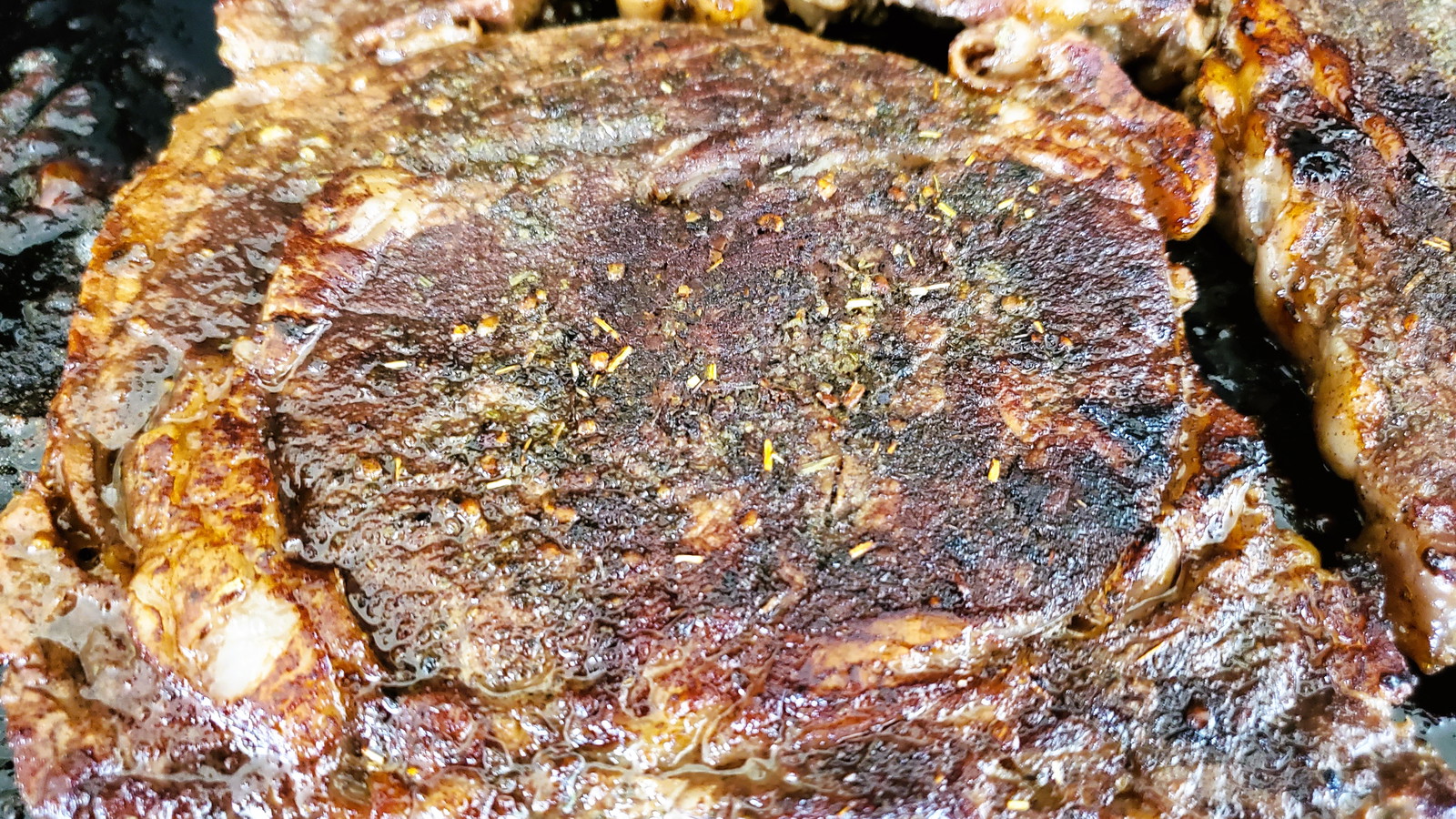 Image of steak cooking on a griddle.