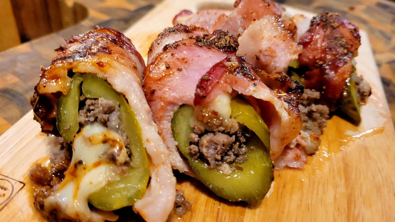 image of a pickle wrapped in bacon stuffed with meat and cheese.