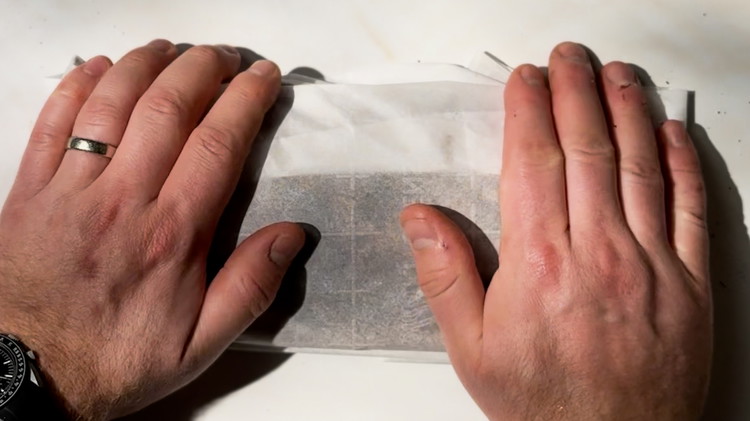 Image of Wrap the fish tightly in the parchment paper, burrito-style, ensuring no air can enter. Place the wrapped fish in a hermetically sealed box or container.