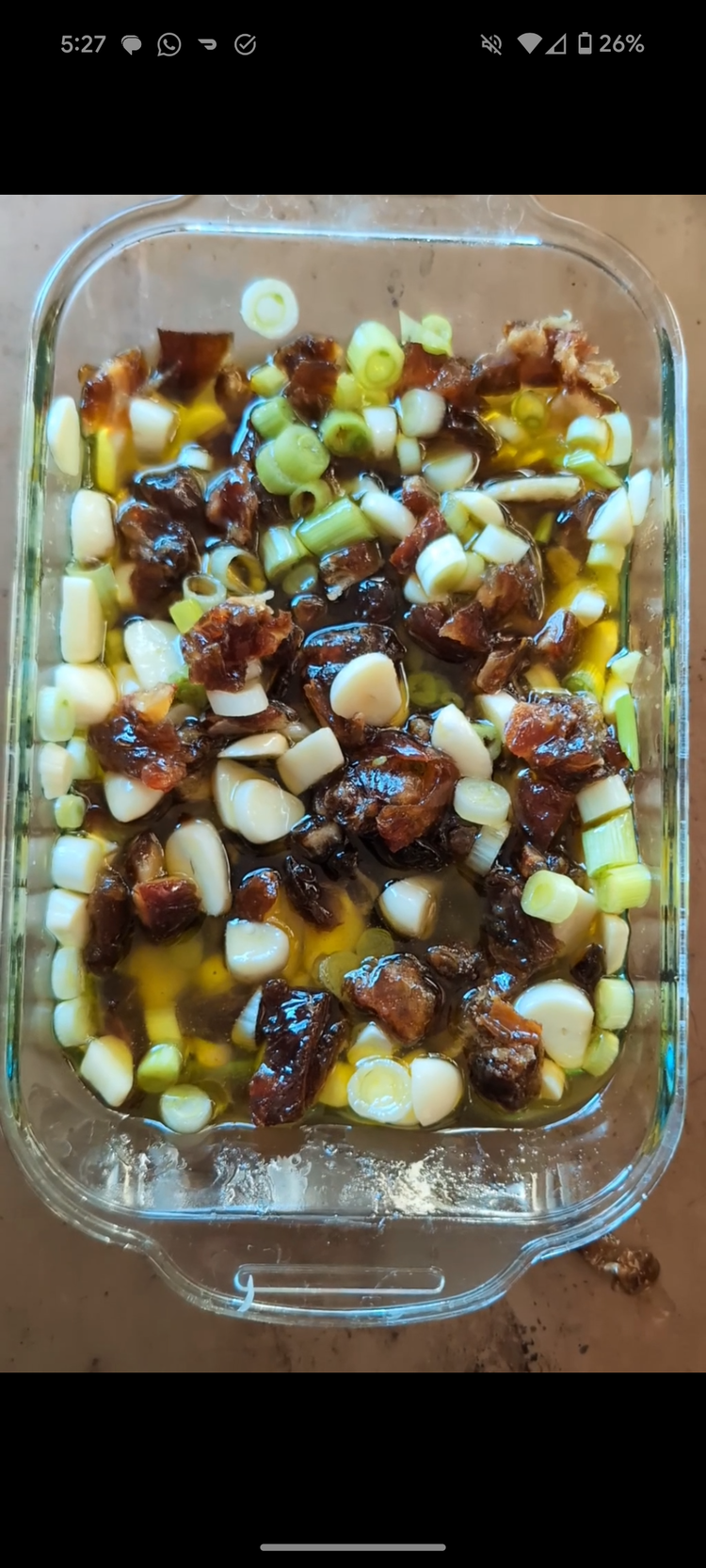 Image of Chop dates, garlic, scallions and place in small baking pan. Pour oil, lemon, salt and mix well. 