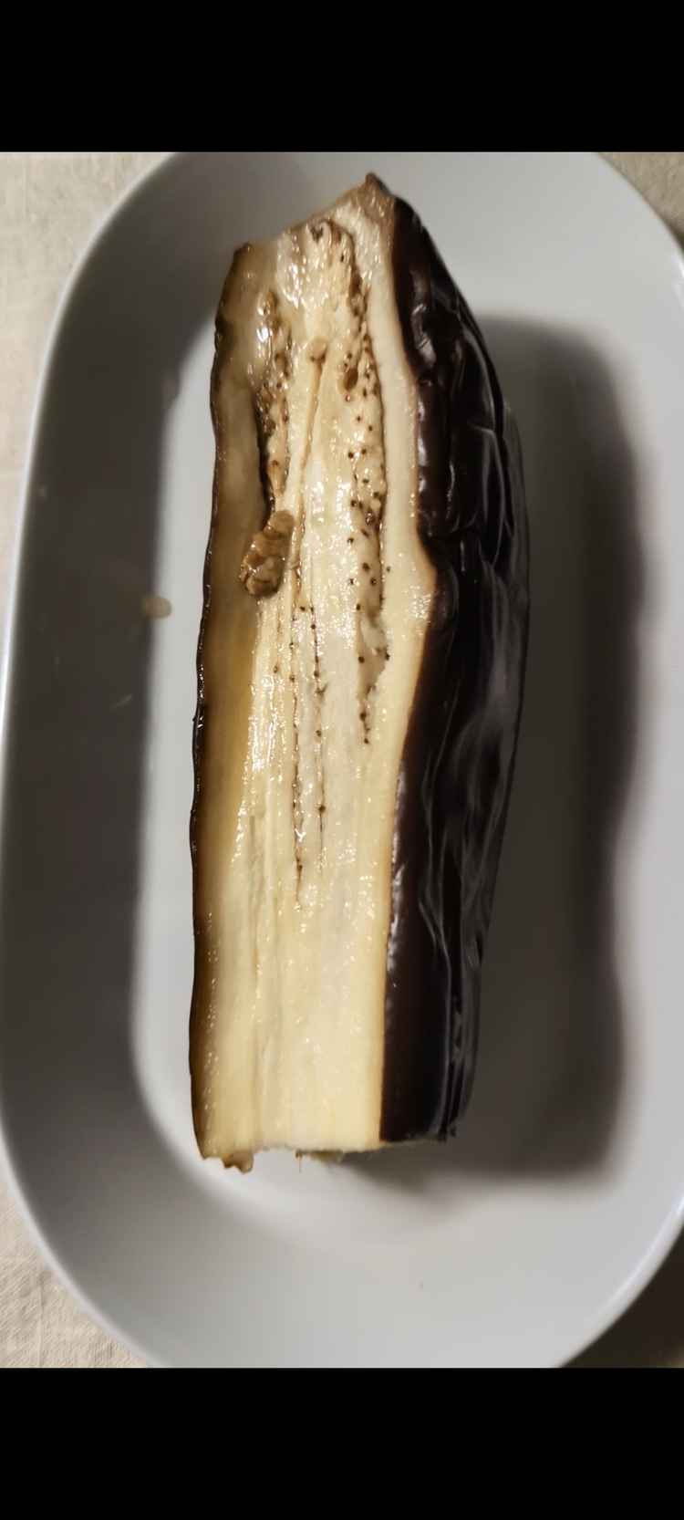 Image of Cut away the head of the eggplant. Cover with foil paper and bake in oven for 400 degrees for 2 hours or until soft.