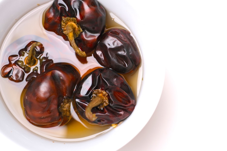 Image of Soak Nora peppers in very hot water for about an hour. Be sure to weigh them down or push them down regularly to allow water to completely soak the peppers