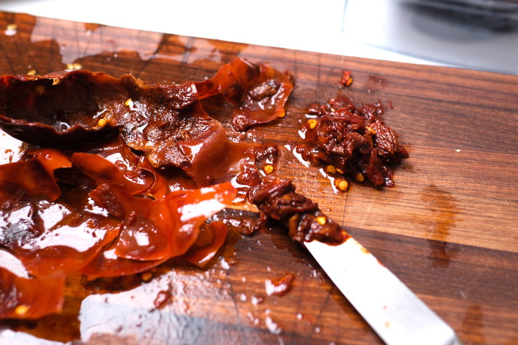 Image of Take a paring knife and carefully scrape off the inside “meat” from the skins of the pepper. It should pull away easily and leave behind a wax-like pepper skin. Discard skins.