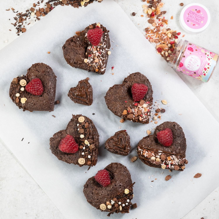 Image of Brownies mit Keksaustecher ausstechen und mit flüssiger Schokolade, den Schoko- und Himbeertopping, sowie den Himbeeren dekorieren.