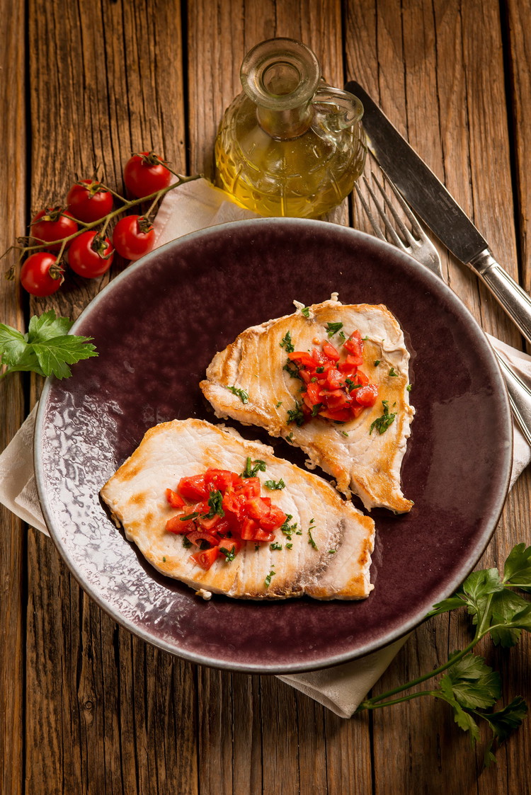 Image of Serve the grilled swordfish topped with the fresh tomato salsa, enjoying the smoky flavors and vibrant freshness.