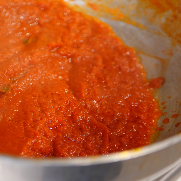Image of Pour in the pureed tomatoes and simmer on low heat...