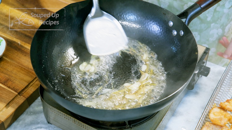 Image of Pour out most of the oil from the wok but leave 1.5 tsps. Use the remaining oil to sauté the garlic slices and julienned ginger until fragrant. Pour in the sweet and sour sauce. Stir over medium heat until the...