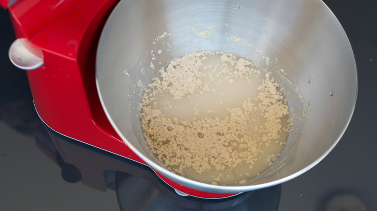 Image of In a mixing bowl combine yeast, sugar with lukewarm water. Cover and allow the yeast to activate. Once activated stir in the egg and olive oil. 