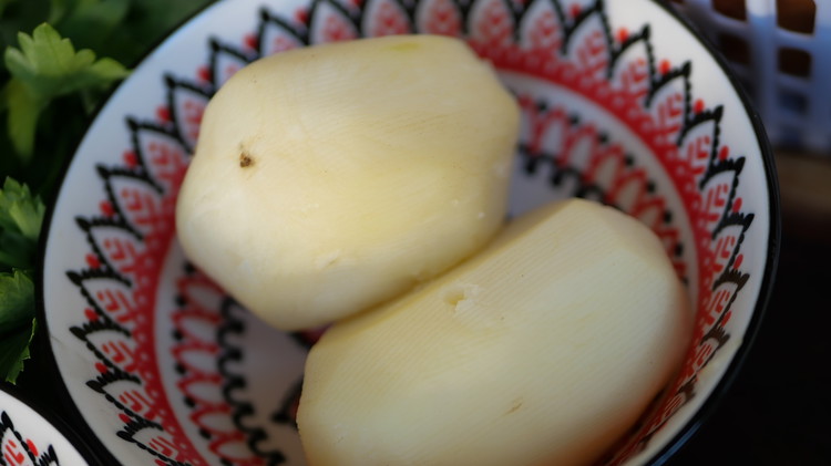 Image of Add peeled and diced potatoes into a saucepan. Fill with water until the potatoes are fully submerged. Add salt to taste and boil until the potatoes are tender but still hold their shape.