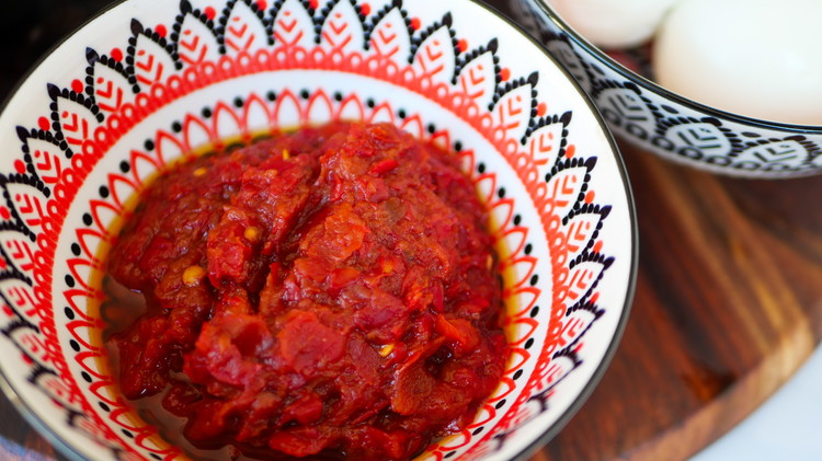 Image of Add harissa paste and olive oil into a bowl and mix until desired consistency has been achieved.