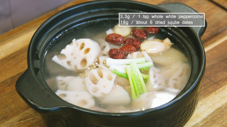 Image of Pour the clean broth into a clay pot. Then, add the blanched ribs, lotus root, ginger slices, the white part of the scallion stalks, white peppercorns, and jujube dates and simmer on low heat for 1.5 hours.