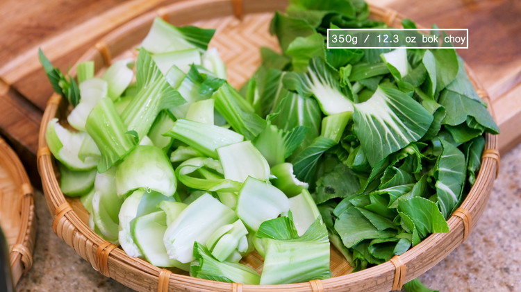 Image of Rinse the bok choy with water and tear the leaves off. Drain thoroughly. Cut the bok choy into bite size pieces and separate the stems and leaves. 