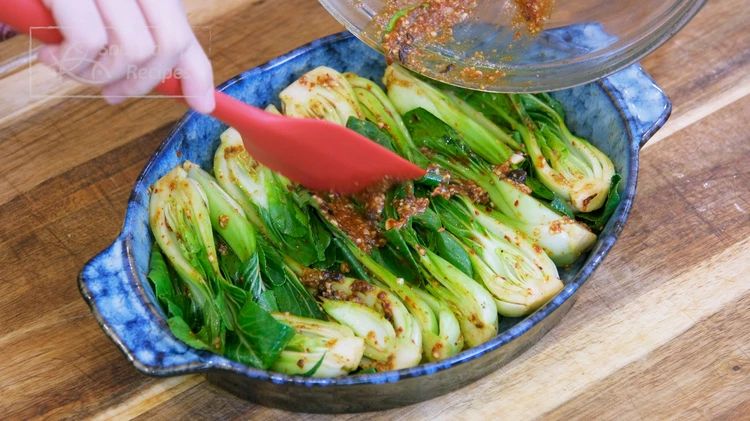 Image of There should be a little bit of seasonings left in the bowl. Use a rubber spatula to scrap it down and evenly spread onto the bok choy.