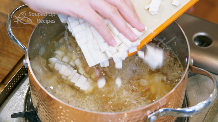 Image of While waiting for it to come to a boil, you should have enough time to dice ½ of a package of tofu and add to the soup to cook. I am using silken tofu but firm tofu will also work....