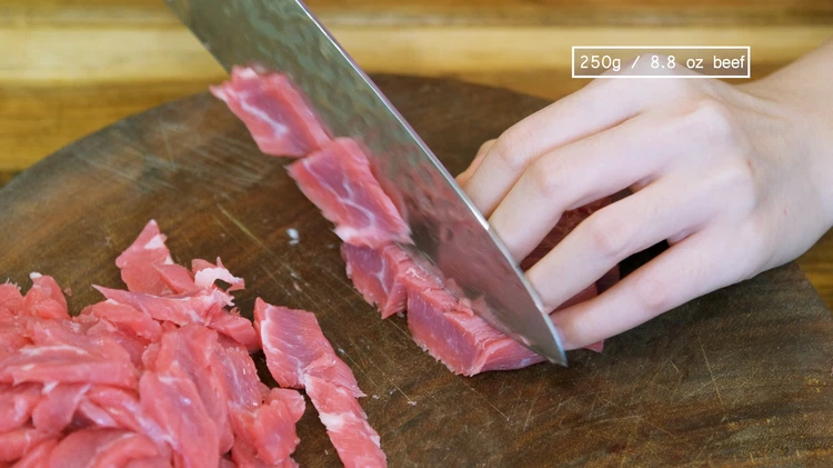Image of Slice the beef into strips. Then, cut the strips into thin and small pieces. I am using flank steak but beef chuck and sirloin will also work well. 
