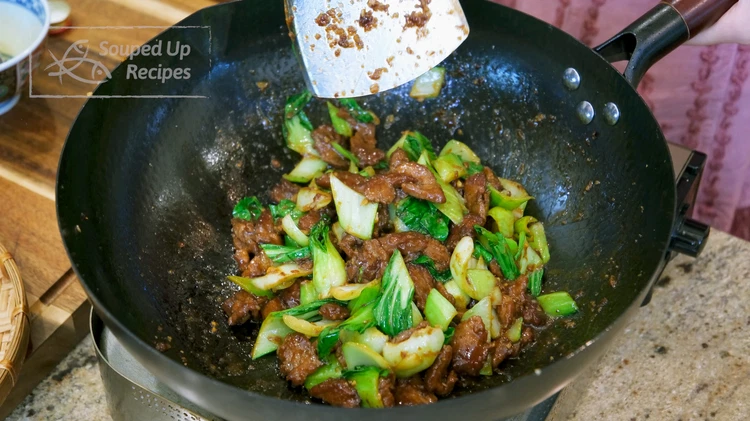 Image of Add the bok choy leaves and keep mixing until the leaves are wilted.