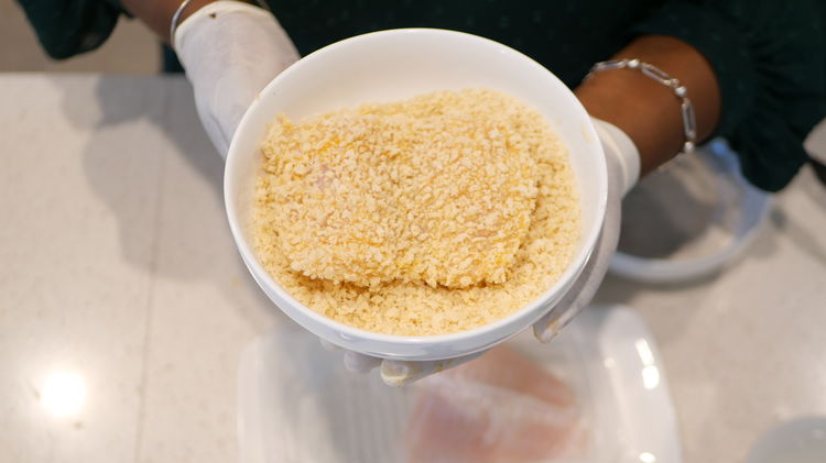 Image of Coat the fillets in the panko bread crumbs. Packing down...