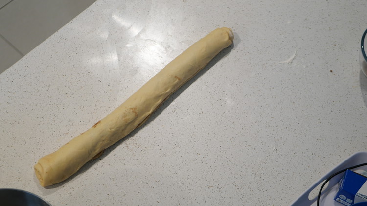 Image of Roll the dough tightly from the long edge and slice into 12 equal rolls.