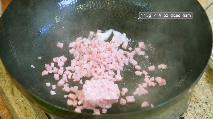 Image of Turn the heat to medium and preheat the wok for 30 seconds. Add 2 Tbsps of pork lark and 4 oz of diced ham. Saute it for a minute or 2. Traditionally, this dish is made with Jinhua ham, a...