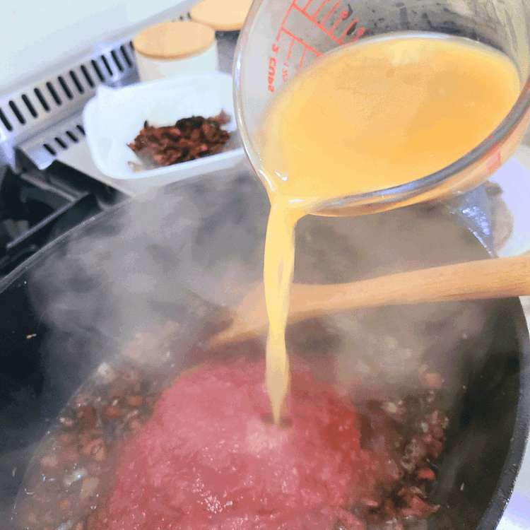 Image of Add the broth, crushed tomatoes, tomato paste, fresh thyme, fresh rosemary, Italian seasoning, bay leaves, dried calabrian chilis, and bacon. Mix all together before adding the buffalo back in.