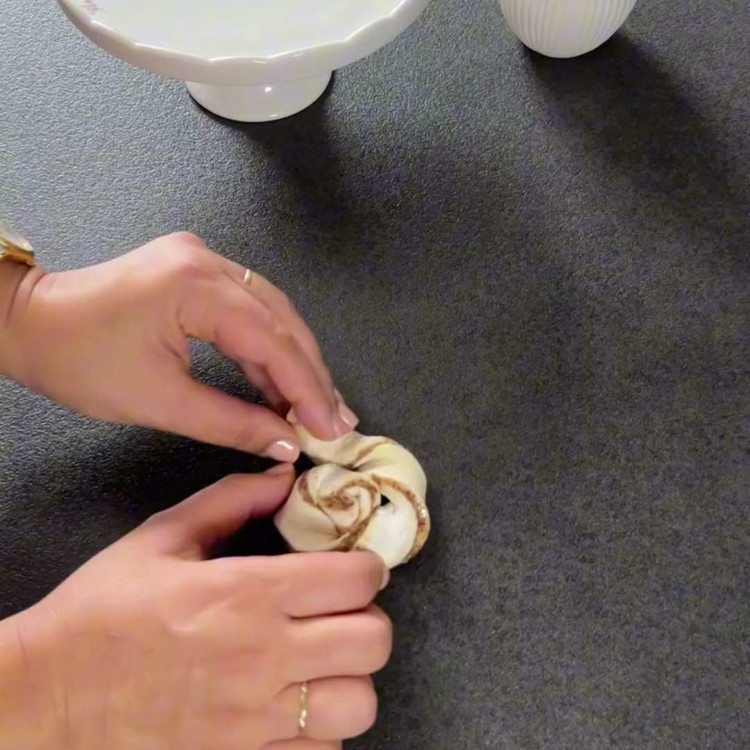 Image of Jeden Streifen vorsichtig zu einer Spirale drehen, dann jeden verdrehten Streifen zu einem Wirbel formen und auf ein mit Backpapier ausgelegtes Backblech legen.