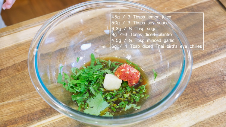 Image of While waiting, make the lemon sauce for the chicken. Add 3 Tbsps lemon juice, 3 Tbsps soy sauce, ½ Tbsp sugar, 3 Tbsps of diced cilantro, ½ Tbsp minced garlic, and 1 Tbsp diced Thai bird’s eye chilies to a...
