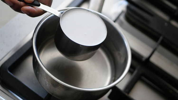 Image of In a saucepan, bring the coconut milk and water to...