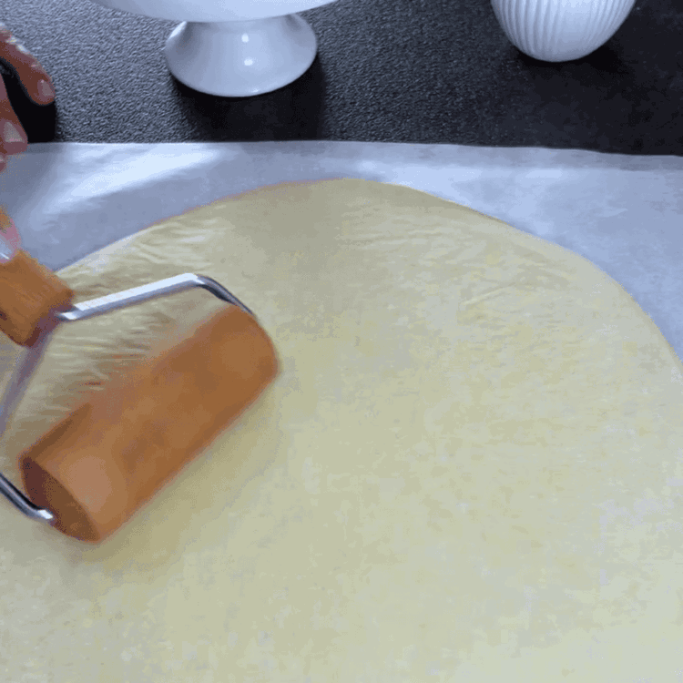 Image of Preheat the oven to 200 degrees Celsius. Roll out the dough on a floured surface or on parchment paper and cut out four equal-sized circles.