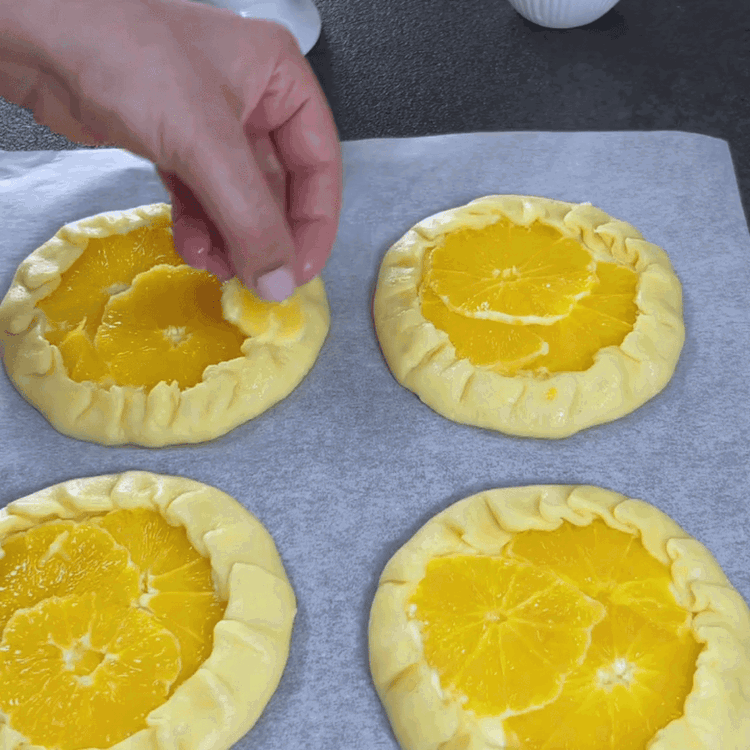Image of Gently fold and seal the edges of the galettes. Brush the edges with some orange juice.