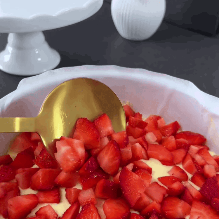 Image of Evenly distribute the strawberry slices on top of the sponge cake.