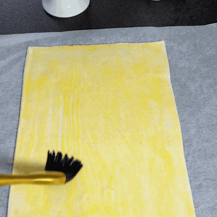 Image of Brush the puff pastry with the beaten egg.