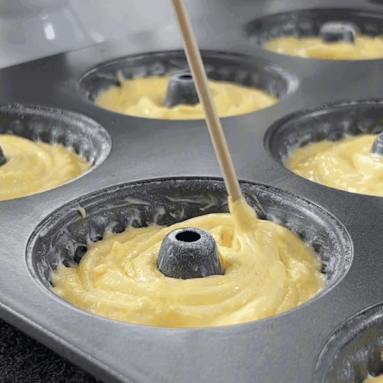 Image of Hamuru mini Gugelhupf kalıplarına eşit şekilde dağıtın ve üstünü düzeltin.