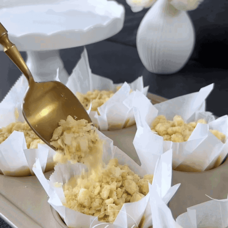 Image of Den Teig gleichmäßig auf die 6 Muffinförmchen verteilen. Den Crumble gleichmäßig über die Muffins streuen.