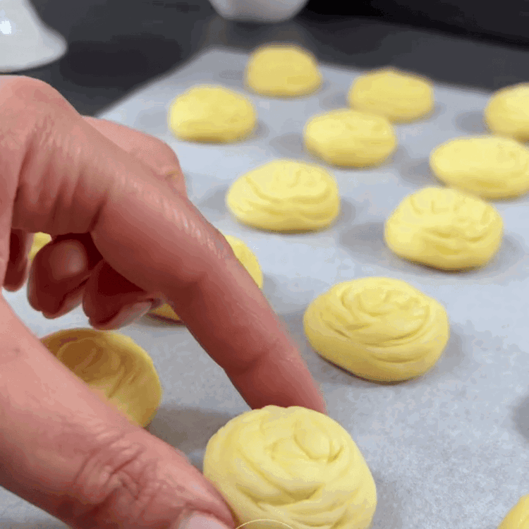 Image of Cuoci i biscotti nel forno preriscaldato per circa 12-15 minuti o fino a quando non sono leggermente dorati.