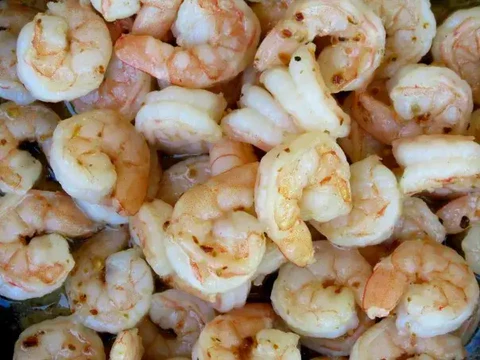 Image of Melt the butter with the garlic in a large sauté pan over medium high heat. Pat shrimp dry, using a paper towel, and add to the pan. Season with salt and pepper flakes, and sauté until fully cooked and opaque,...