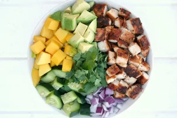 Image of Place lettuce into the bottom of 2 bowls. Place all ingredients into groups on top of the lettuce, or just combine everything into a large bowl.