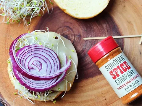 Image of Heat on the grill or skillet over oil until starting to brown on the top and bottom. Add patties to a bun with mayo, sprouts, cheese, and red onion.
