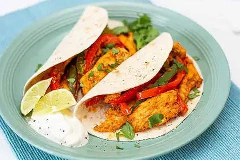 Image of Spoon filling down the center of tortillas, fold in half....