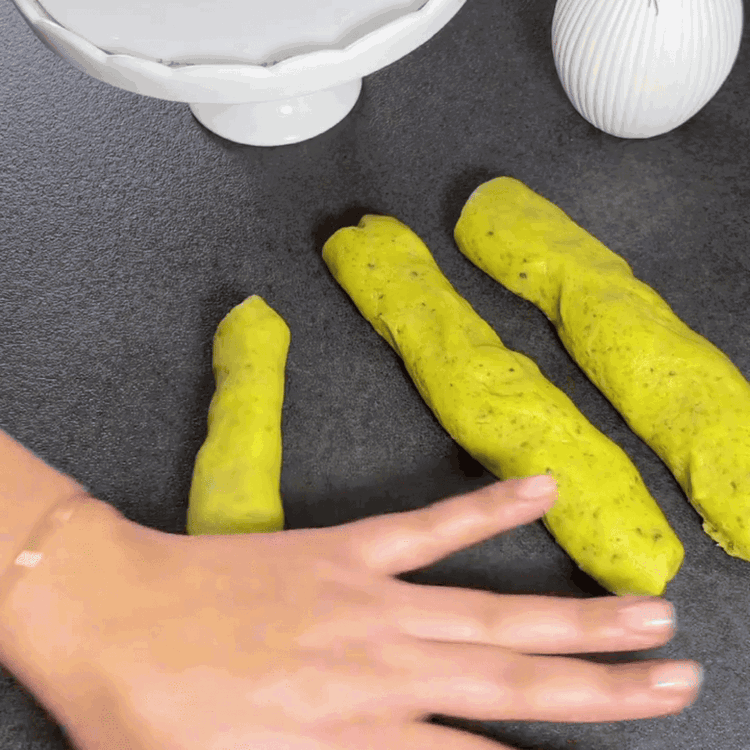 Image of Forma alrededor de 25 bolas pequeñas de la masa (aprox. 25g por bola) y luego dales forma rectangular, colocándolas en una bandeja para hornear forrada con papel pergamino.