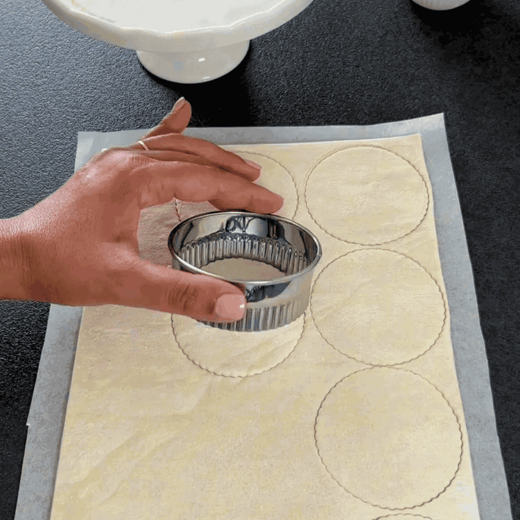Image of Stechen Sie Ringe aus dem Blätterteig aus. Schneiden Sie aus der Hälfte dieser Ringe ein kleineres Loch in die Mitte und legen Sie sie auf die ungeschnittenen Ringe, um einen Rand zu bilden. Drücken Sie die Ränder leicht zusammen. Wenn...
