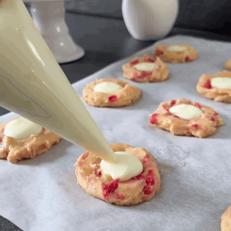 Image of Cubre las galletas rellenas con pequeños trozos de masa, cubriendo el relleno. Usa una cuchara para tirar suavemente la masa de abajo hacia arriba, formando una bola. Espolvorea con virutas de chocolate blanco.