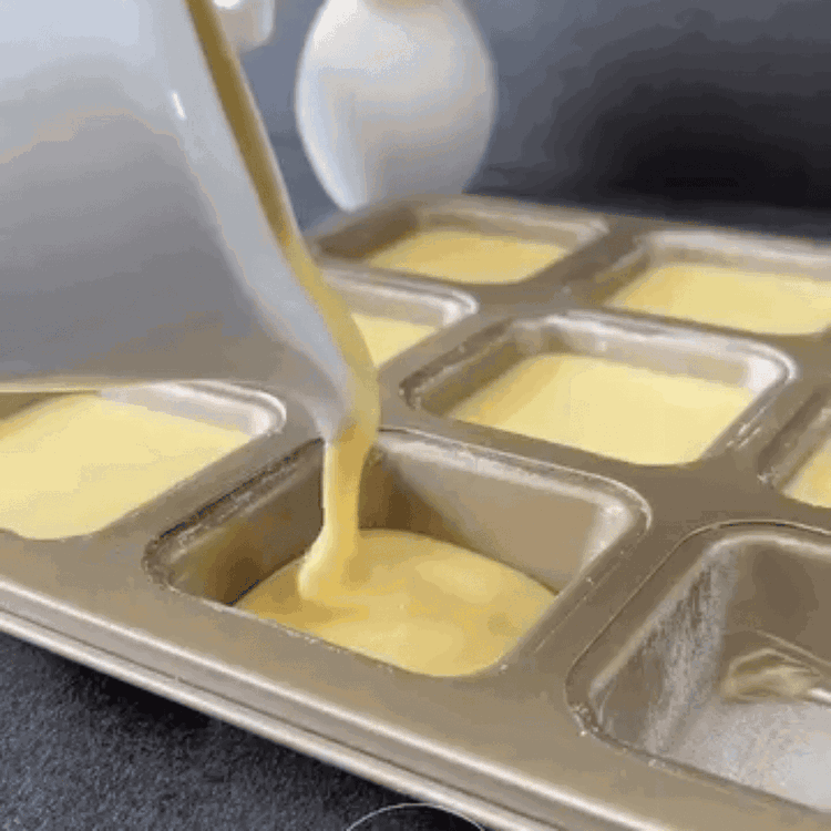 Image of Evenly distribute the batter into the 12 wells of the...